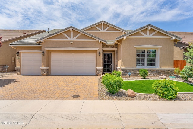 9425 Stony Hill Rd, Reno, NV 89521 - view of front of home with stone siding, stucco siding, decorative driveway, and a garage