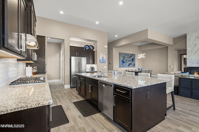 9425 Stony Hill Rd, Reno, NV 89521 - kitchen with stainless steel appliances, a sink, a kitchen bar, light wood finished floors, and recessed lighting