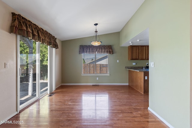 439 Beau Ct, Sparks, NV 89436 - unfurnished dining area featuring plenty of natural light, light wood-style floors, lofted ceiling, and baseboards