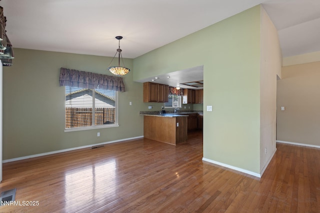 439 Beau Ct, Sparks, NV 89436 - kitchen with brown cabinetry, a peninsula, wood finished floors, and open floor plan