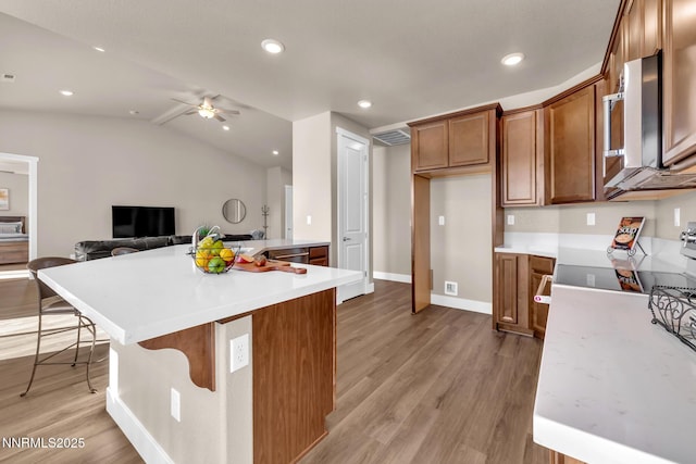 255 Pinto Ranch Ct, Reno, NV 89510 - kitchen with light wood finished floors, stainless steel microwave, light countertops, ceiling fan, and lofted ceiling