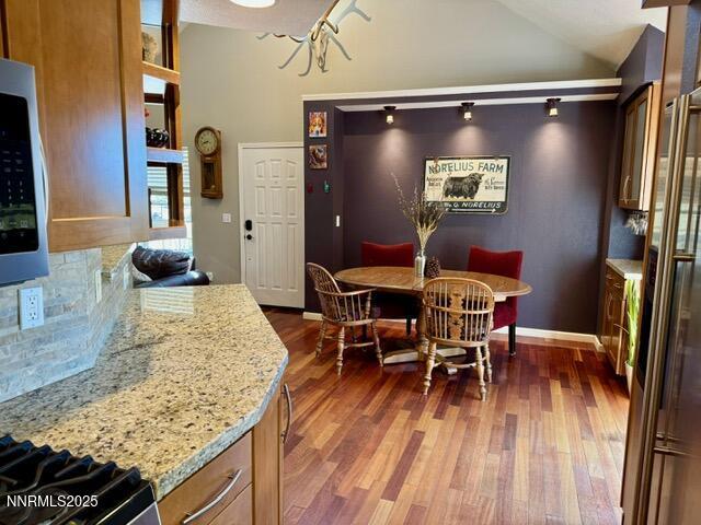 3205 Kingsview Ct, Reno, NV 89512 - dining area featuring dark wood-style flooring, lofted ceiling, and baseboards