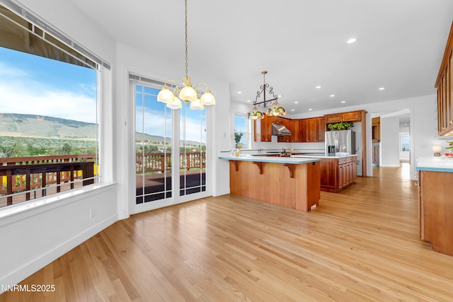 615 Oxbow Ct, Reno, NV 89511 - kitchen with stainless steel fridge with ice dispenser, a chandelier, a breakfast bar area, extractor fan, and light countertops