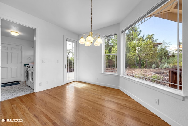 615 Oxbow Ct, Reno, NV 89511 - unfurnished dining area featuring washer and dryer, a chandelier, baseboards, and light wood-style floors
