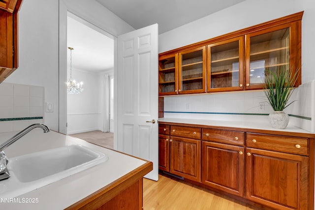 615 Oxbow Ct, Reno, NV 89511 - kitchen with a sink, light countertops, tasteful backsplash, a chandelier, and glass insert cabinets