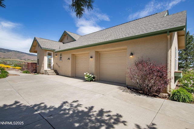 615 Oxbow Ct, Reno, NV 89511 - view of side of home with stucco siding, roof with shingles, an attached garage, and concrete driveway