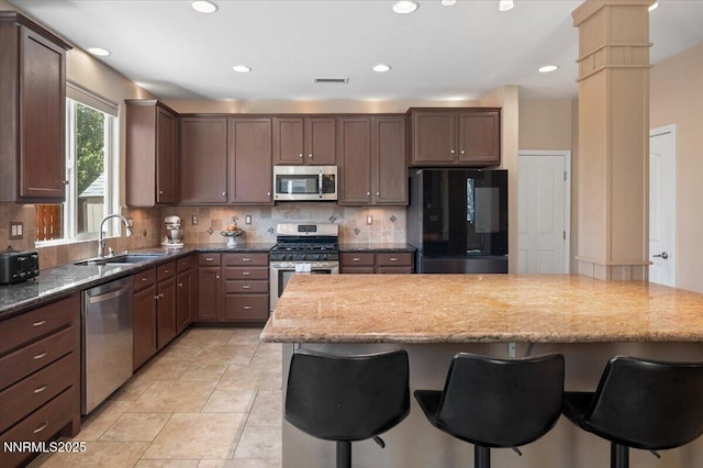 400 Sondrio Ct, Reno, NV 89521 - kitchen featuring stainless steel appliances, a sink, a breakfast bar area, decorative backsplash, and recessed lighting