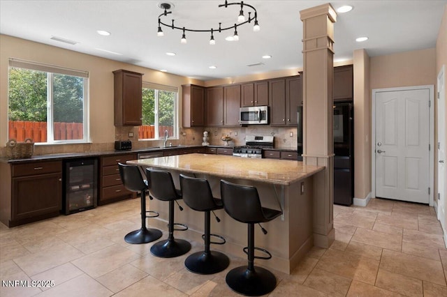 400 Sondrio Ct, Reno, NV 89521 - kitchen featuring appliances with stainless steel finishes, wine cooler, a sink, a center island, and plenty of natural light