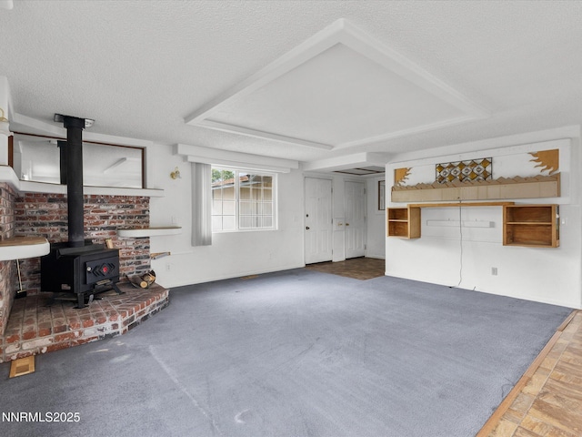 1344 Patricia Dr, Gardnerville, NV 89460 - unfurnished living room featuring a wood stove, a raised ceiling, and a textured ceiling