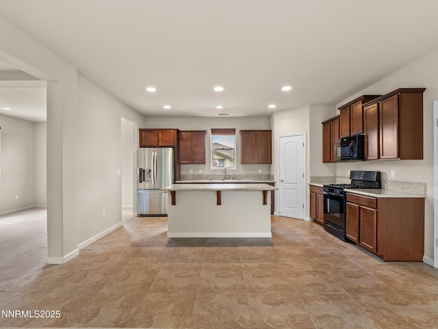 1105 Fiore Ct, Minden, NV 89423 - kitchen with black appliances, a breakfast bar, recessed lighting, a kitchen island, and a sink