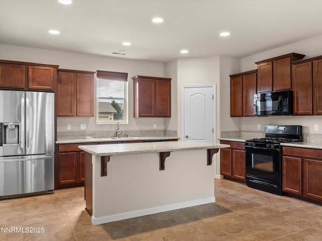 1105 Fiore Ct, Minden, NV 89423 - kitchen featuring black appliances, a breakfast bar area, light stone counters, a sink, and recessed lighting