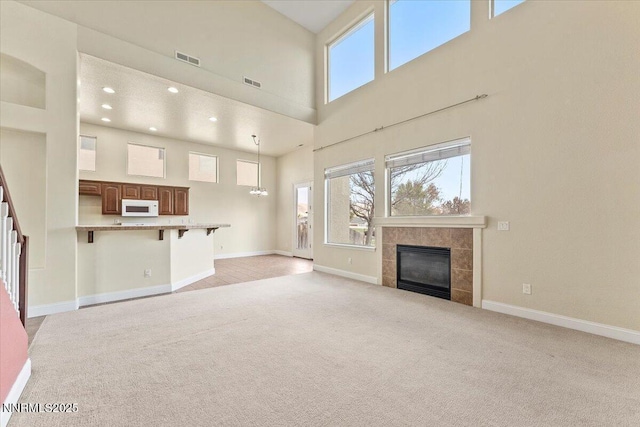 1239 Flintwood Dr, Carson City, NV 89703 - unfurnished living room featuring light colored carpet, a tile fireplace, a high ceiling, baseboards, and recessed lighting