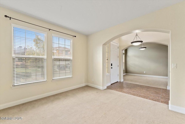1239 Flintwood Dr, Carson City, NV 89703 - carpeted spare room with arched walkways, baseboards, and tile patterned flooring