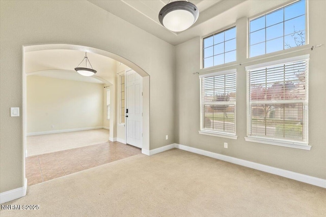 1239 Flintwood Dr, Carson City, NV 89703 - carpeted spare room featuring arched walkways, baseboards, and tile patterned floors