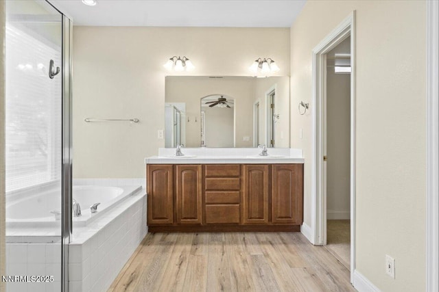 1239 Flintwood Dr, Carson City, NV 89703 - bathroom featuring double vanity, a garden tub, plenty of natural light, and wood finished floors