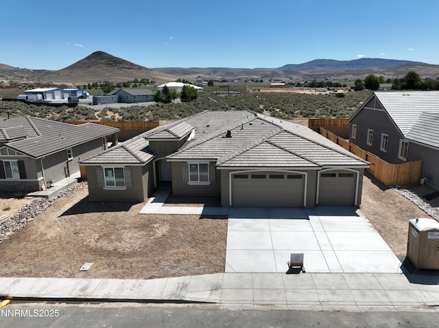 2350 Seaberry Dr, Sparks, NV 89441 - ranch-style house featuring a mountain view, a garage, concrete driveway, and a tiled roof