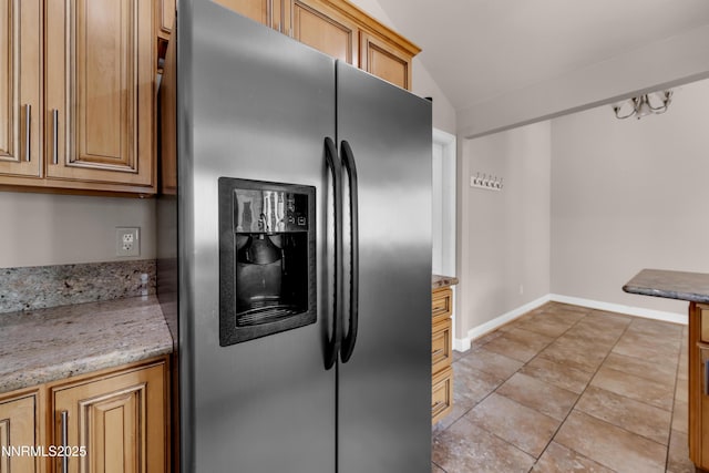 1220 Conway Ln, Reno, NV 89503 - kitchen featuring stainless steel fridge with ice dispenser, vaulted ceiling, light stone countertops, and light tile patterned flooring