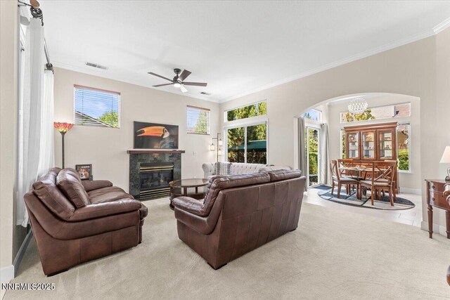 1328 Windridge Dr, Carson City, NV 89706 - living room with arched walkways, crown molding, a high end fireplace, a ceiling fan, and light colored carpet