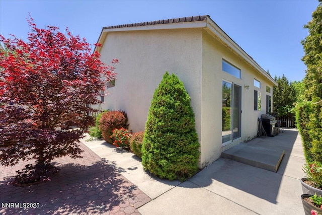 1328 Windridge Dr, Carson City, NV 89706 - view of side of home featuring stucco siding and a patio