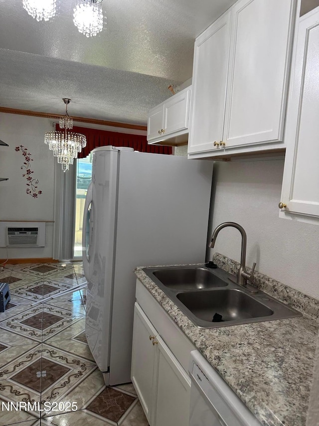 3926 Clear Acre Ln Unit 107, Reno, NV 89512 - kitchen featuring a sink, an AC wall unit, a chandelier, white cabinets, and a textured ceiling