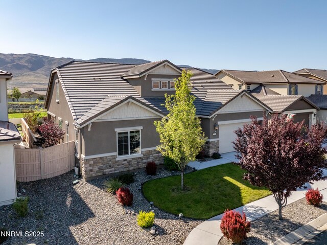 10260 Rollins Dr, Reno, NV 89521 - view of front of house with stone siding, an attached garage, and stucco siding