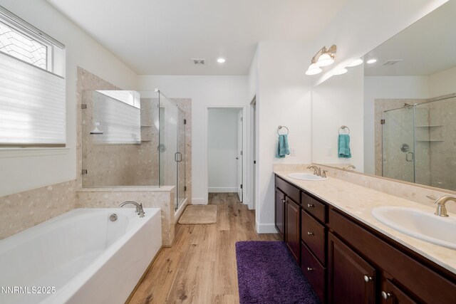 10260 Rollins Dr, Reno, NV 89521 - full bath featuring a stall shower, double vanity, a bath, and wood finished floors