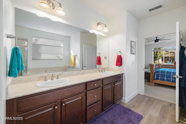 10260 Rollins Dr, Reno, NV 89521 - ensuite bathroom with wood finished floors, double vanity, ceiling fan, and baseboards