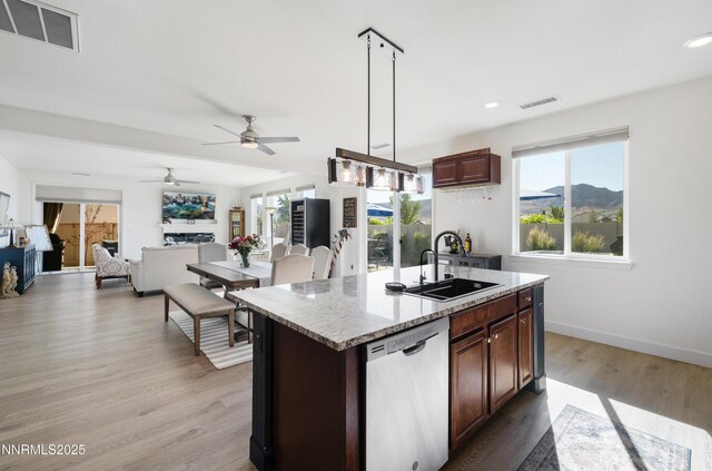 10260 Rollins Dr, Reno, NV 89521 - kitchen featuring dishwasher, a sink, a ceiling fan, a kitchen island with sink, and hanging light fixtures