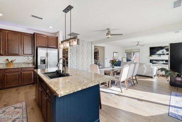 10260 Rollins Dr, Reno, NV 89521 - kitchen featuring a sink, stainless steel refrigerator with ice dispenser, a ceiling fan, light wood-type flooring, and light stone counters