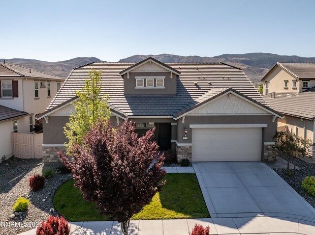 10260 Rollins Dr, Reno, NV 89521 - craftsman-style house featuring stone siding, an attached garage, a mountain view, and driveway