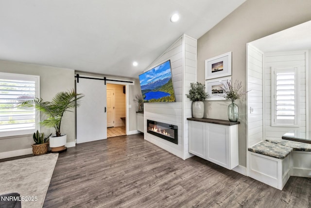 772 Mammoth Way, Gardnerville, NV 89460 - unfurnished living room with vaulted ceiling, a barn door, wood finished floors, recessed lighting, and a large fireplace