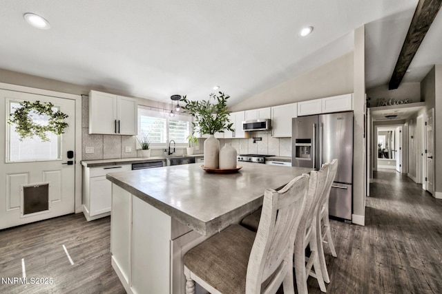772 Mammoth Way, Gardnerville, NV 89460 - kitchen with appliances with stainless steel finishes, tasteful backsplash, a center island, white cabinets, and lofted ceiling