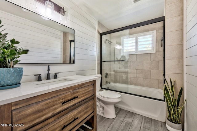 772 Mammoth Way, Gardnerville, NV 89460 - full bathroom featuring vanity, toilet, bath / shower combo with glass door, wood finished floors, and wooden walls