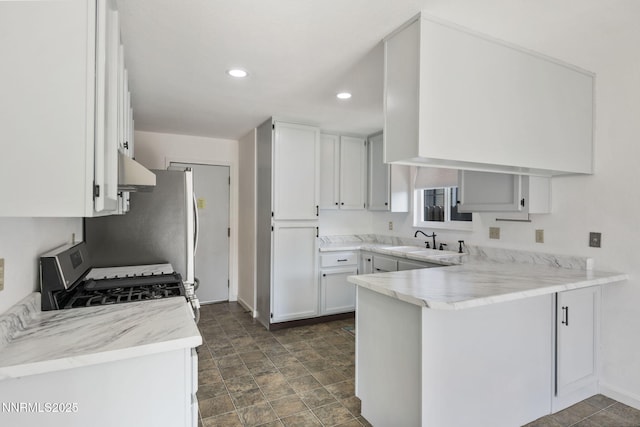 103 Woodlake Ct, Dayton, NV 89403 - kitchen with stainless steel appliances, a sink, a peninsula, under cabinet range hood, and baseboards