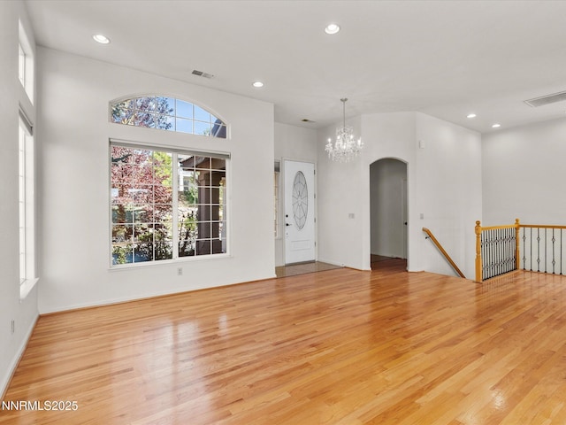 4943 Foxcreek Trl, Reno, NV 89519 - unfurnished living room featuring light wood finished floors, arched walkways, recessed lighting, and a chandelier