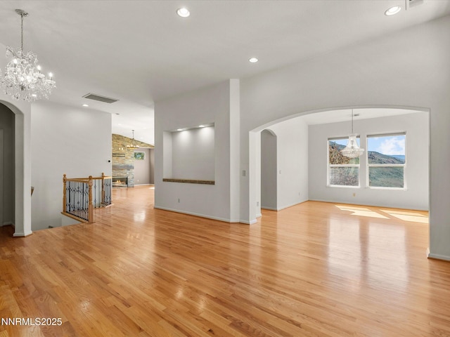4943 Foxcreek Trl, Reno, NV 89519 - unfurnished living room featuring arched walkways, light wood finished floors, recessed lighting, and a chandelier