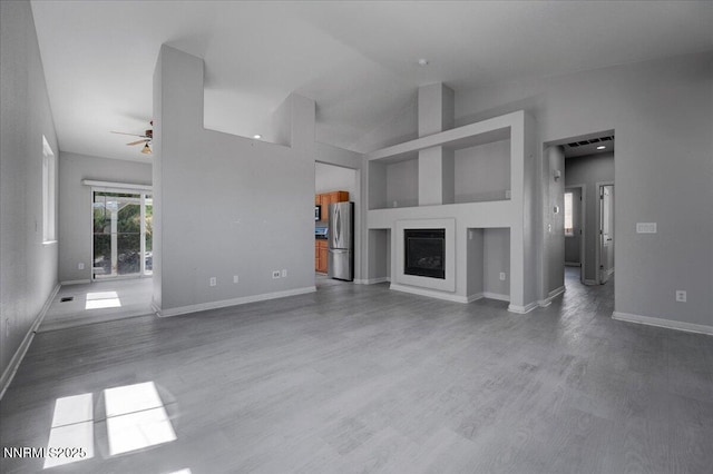 5737 Sonora Pass Dr, Sparks, NV 89436 - unfurnished living room with a ceiling fan, wood finished floors, a fireplace, baseboards, and vaulted ceiling