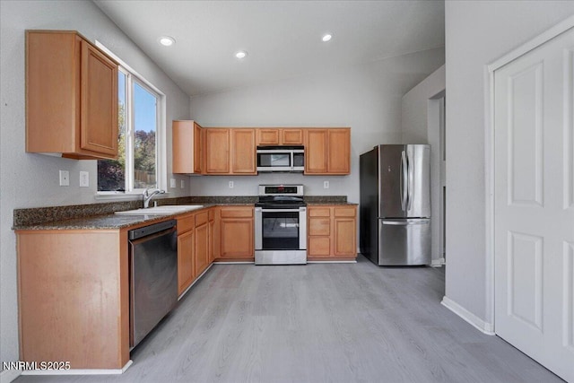5737 Sonora Pass Dr, Sparks, NV 89436 - kitchen with stainless steel appliances, a sink, light wood-type flooring, dark countertops, and vaulted ceiling