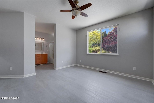 5737 Sonora Pass Dr, Sparks, NV 89436 - unfurnished bedroom with light wood finished floors, baseboards, ensuite bathroom, and a ceiling fan