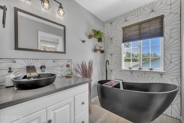7395 Pah Rah Dr, Sparks, NV 89436 - full bathroom with a freestanding tub, vanity, baseboards, and wood finished floors