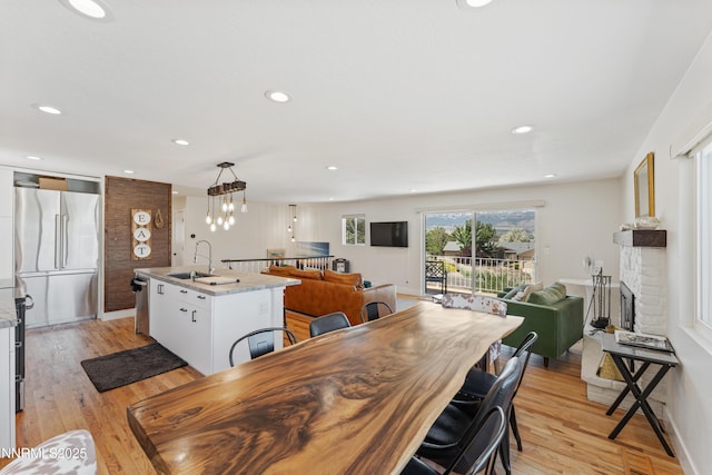 13820 Virginia Foothills Dr, Reno, NV 89521 - dining space featuring a fireplace, light wood-style flooring, recessed lighting, a chandelier, and baseboards