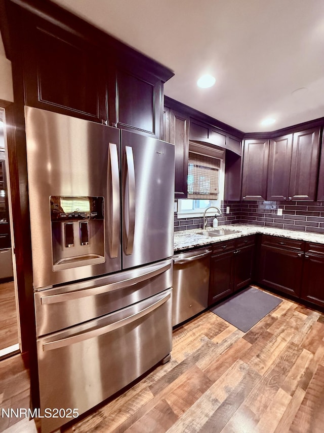 3100 Pine Ln, Carson City, NV 89706 - kitchen featuring stainless steel appliances, a sink, decorative backsplash, light stone countertops, and light wood-style floors