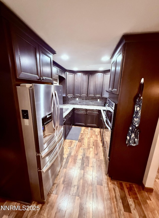 3100 Pine Ln, Carson City, NV 89706 - kitchen with appliances with stainless steel finishes, tasteful backsplash, light wood-style flooring, dark brown cabinetry, and light stone counters