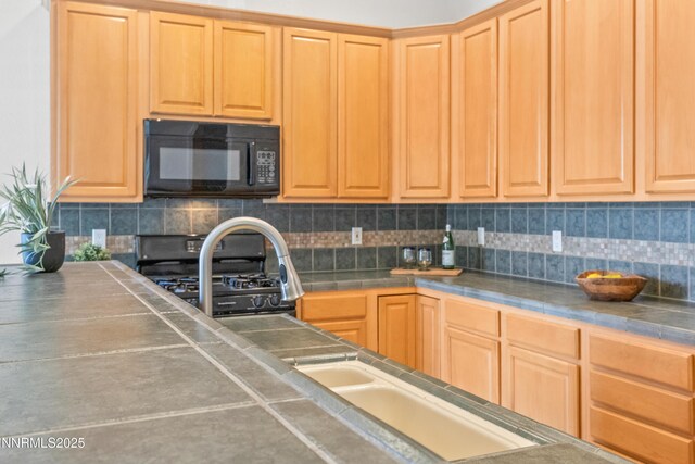 6638 Aston Cir, Sparks, NV 89436 - kitchen with black microwave, backsplash, light brown cabinetry, range, and tile countertops