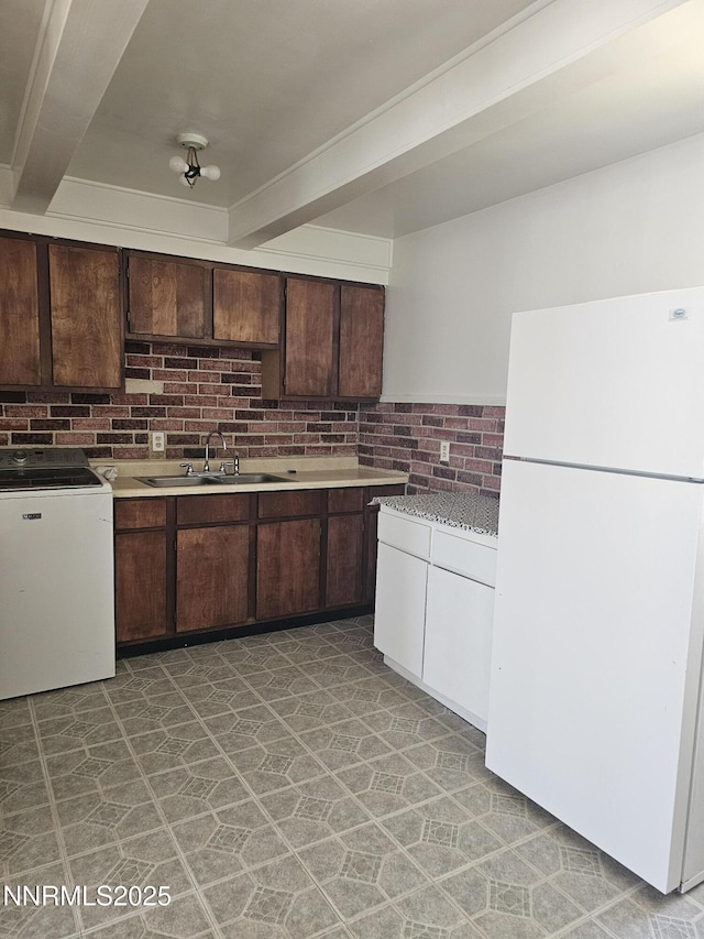 121 English St, Hawthorne, NV 89415 - kitchen with freestanding refrigerator, a sink, dark brown cabinetry, light countertops, and beamed ceiling