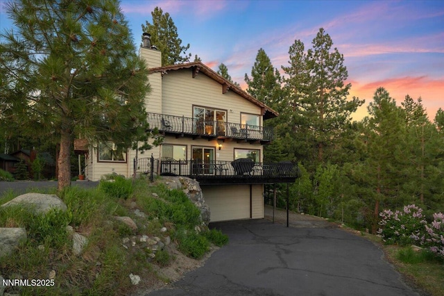 610 Don Dr, Zephyr Cove, NV 89448 - view of front of home with a balcony, driveway, an attached garage, and a chimney