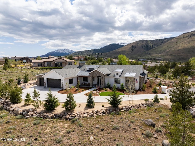 6300 Trailblazer Ct, Reno, NV 89511 - view of front facade with concrete driveway, an attached garage, a mountain view, and stone siding