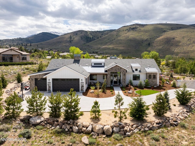 6300 Trailblazer Ct, Reno, NV 89511 - view of front of house with an attached garage, stone siding, driveway, a mountain view, and board and batten siding