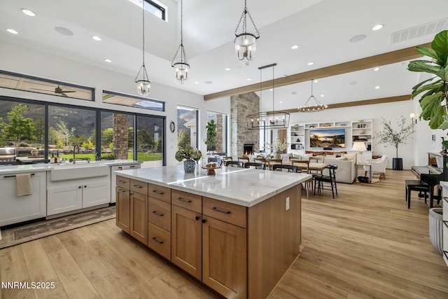 6300 Trailblazer Ct, Reno, NV 89511 - kitchen with a sink, light stone countertops, light wood-type flooring, open floor plan, and decorative light fixtures