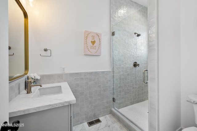 6300 Trailblazer Ct, Reno, NV 89511 - bathroom featuring a stall shower, vanity, toilet, tile walls, and marble look tiles